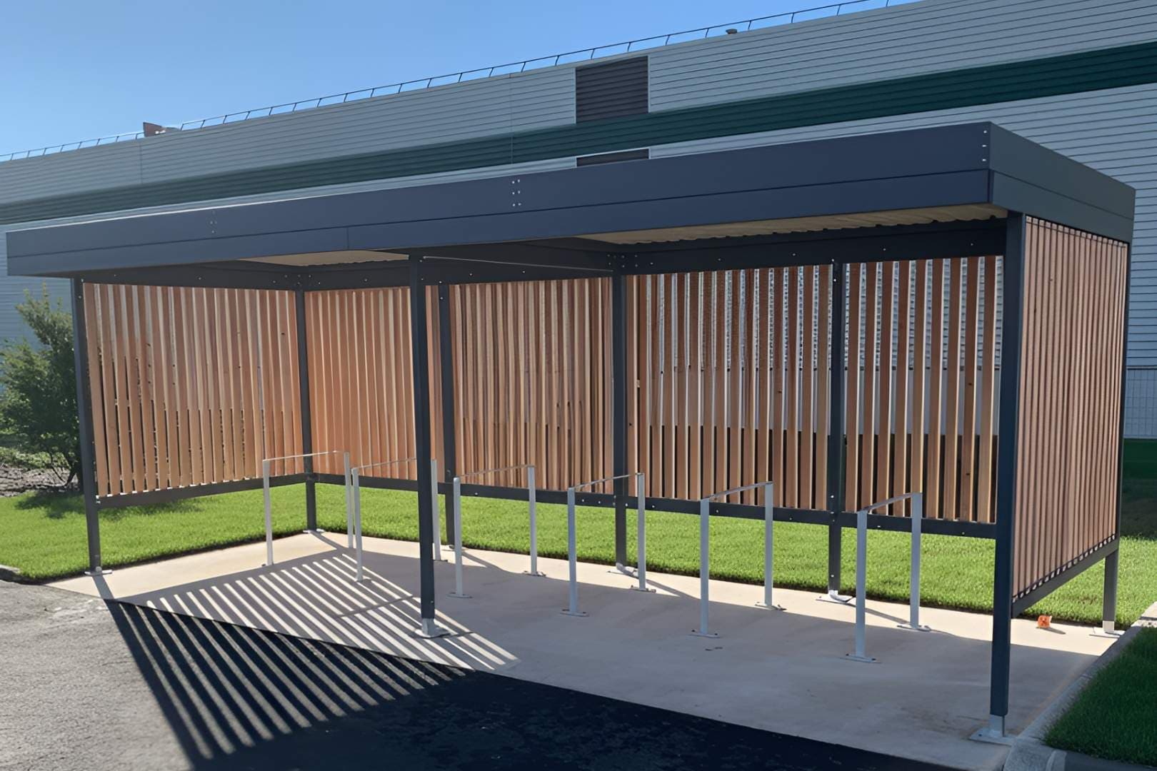 Abri vélo Naturis Steelbox en acier galvanisé anthracite et bardage bois vertical sur dalle béton