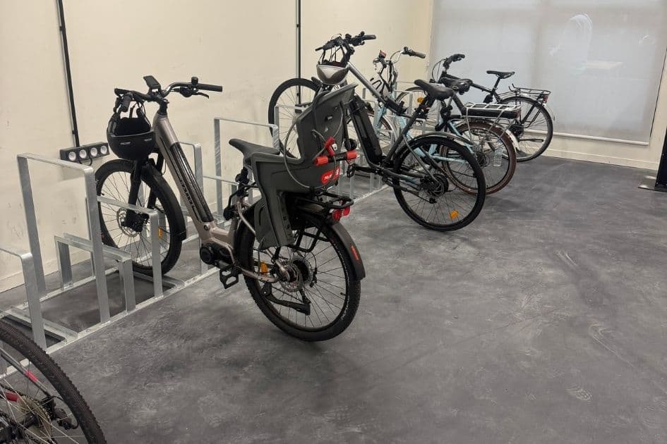 Local vélo intérieur aménagé avec arceaux et racks au sol Steelbox en acier galvanisé, plusieurs vélos garés