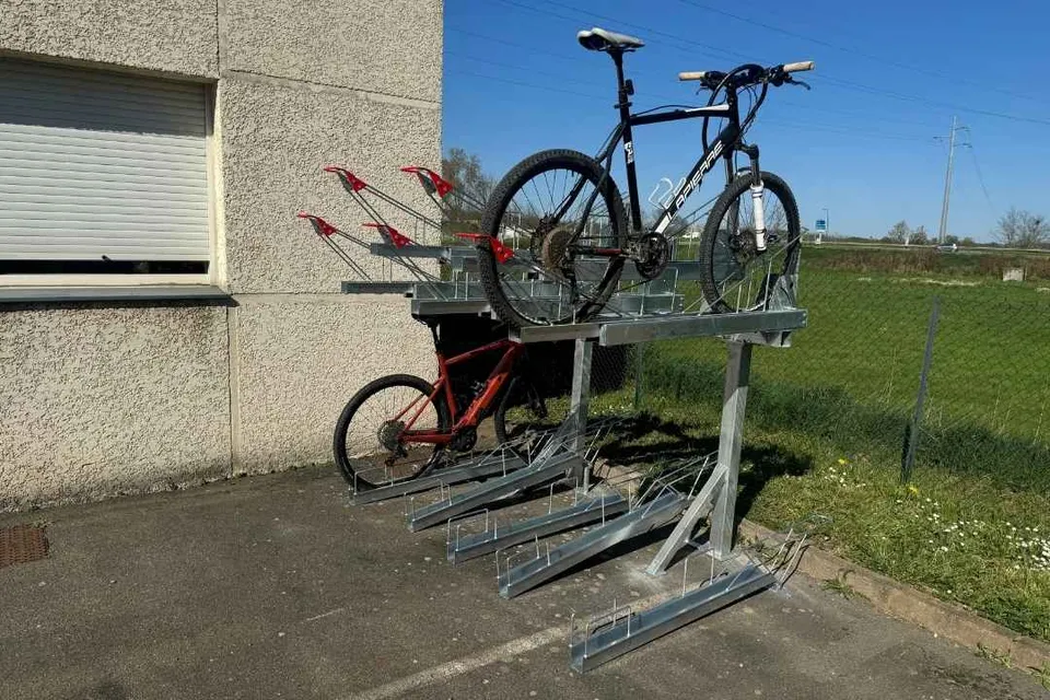 Rack vélo double étage Cyclift en acier galvanisé, un vélo rangé à l'étage supérieur et un au niveau bas, installé en extérieur