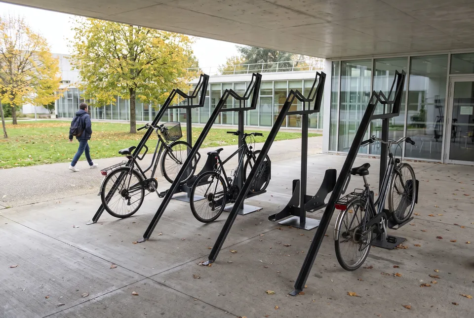 Racks vélo Tripléo 3 emplacements en acier anthracite installés sous l'auvent d'un bâtiment de campus