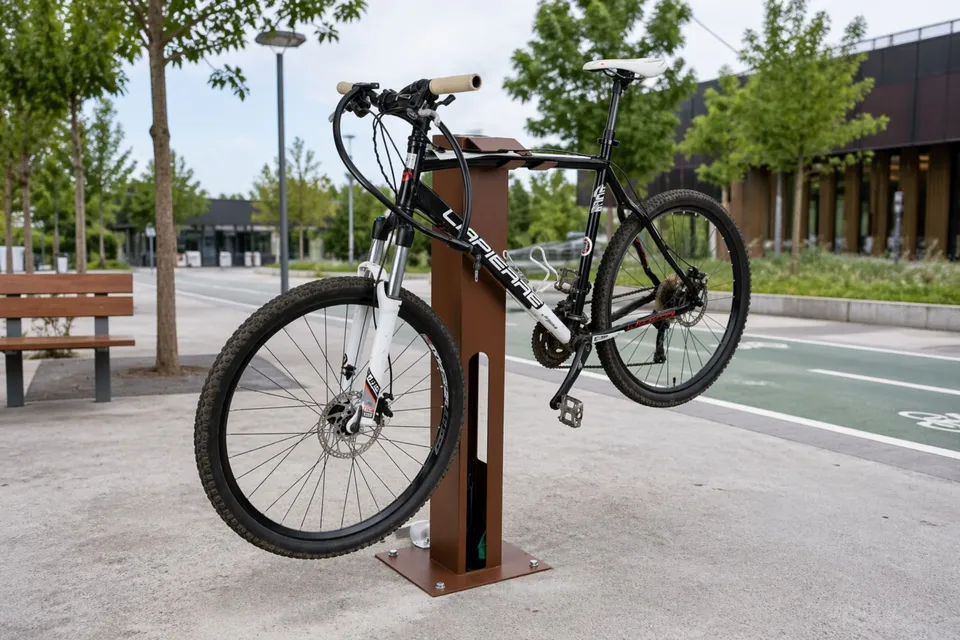 Station de réparation vélo avec un VTT suspendu sur son support, en bord de piste cyclable