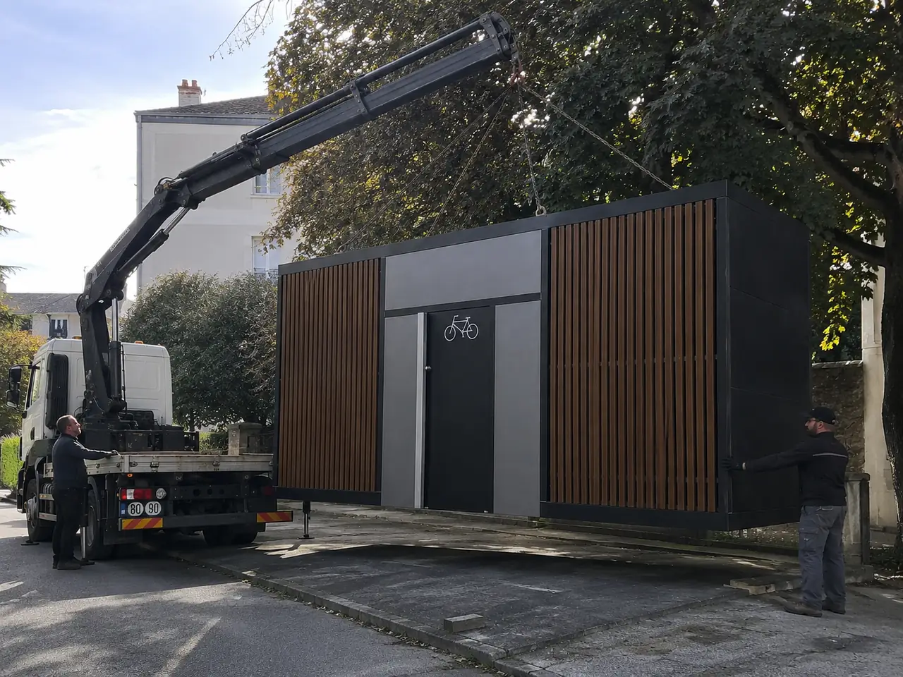 Box vélo pré-assemblé déposé au camion-grue devant un immeuble par l'équipe Steelbox